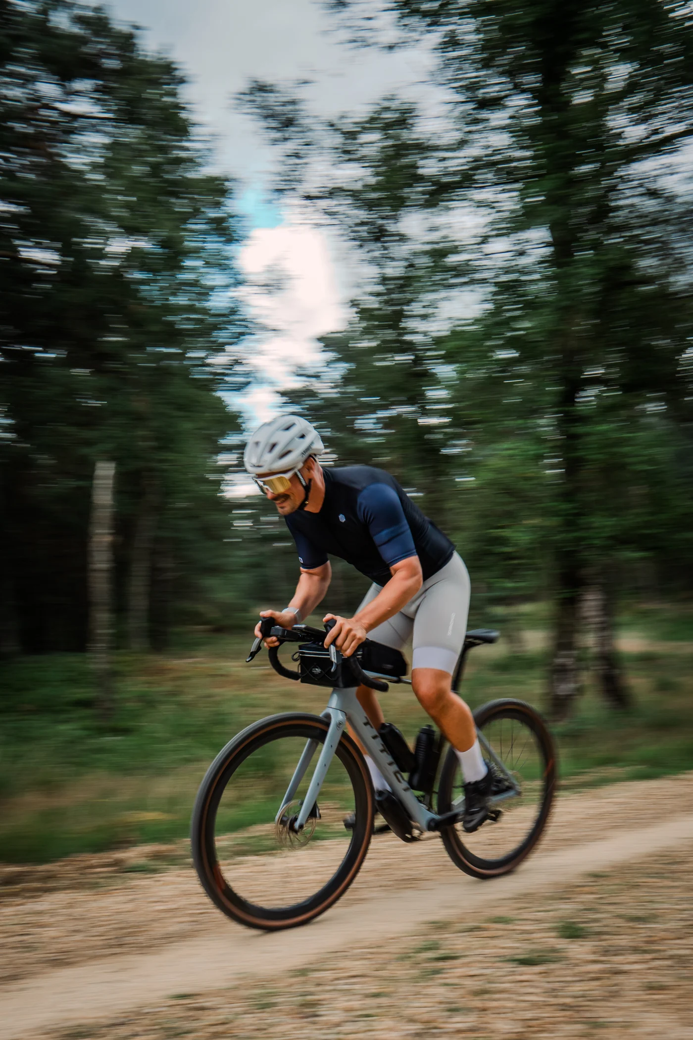 Cycliste sur une route bordée de forêt